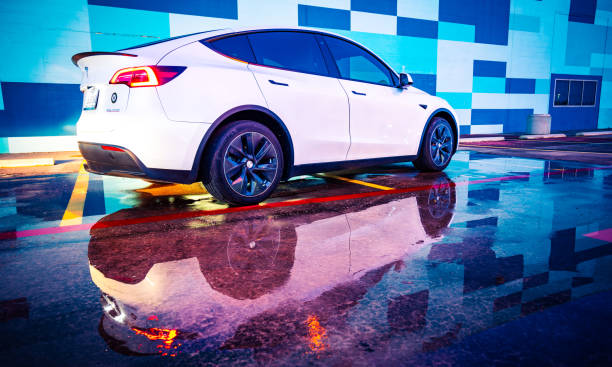 Tesla Model Y Austin , Texas , USA - September 9th 2020: White Tesla Model Y with amazing colorful background pattern with water reflections and modern design tesla model 3 stock pictures, royalty-free photos & images