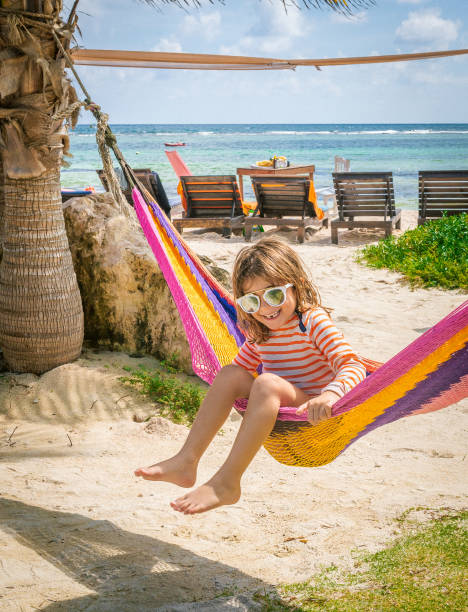 istock Cute kid in a colorful beachfront hammock wearing sunglasses 1282681480