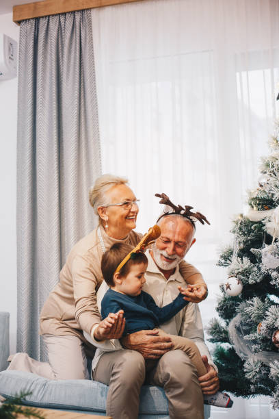 istock Grandparents with their grandson are playing under Christmas tree. 1282681584