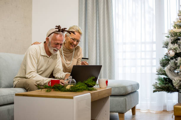 Senior couple doing shopping online. Christmas theme. stock photo