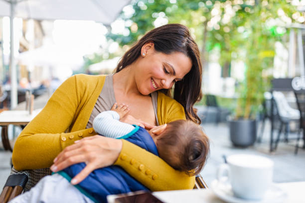 Breast feeding in public place Young mother breastfeeding her baby boy in public while sitting in a cafe breastfeeding photos stock pictures, royalty-free photos & images
