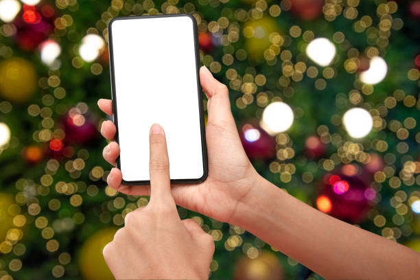 istock Close up hand holding phone isolated on white background with Illuminated  blurred bokeh of  Christmas tree decoration with  hanging lights ball. 1282686574
