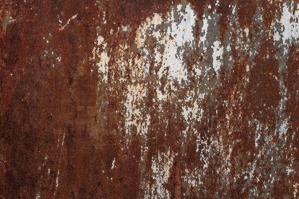 istock Texture of rusty old metal plate with cracked white paint. 1282690119