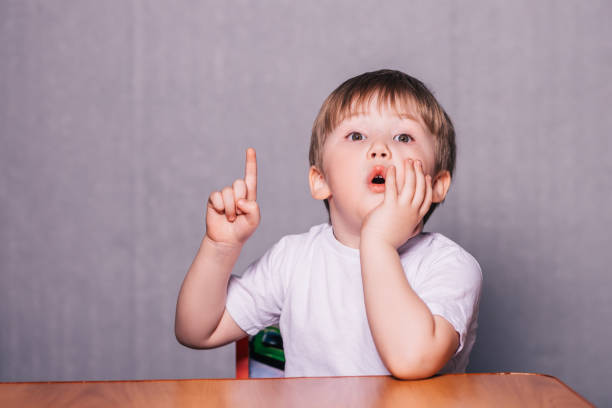 Little boy sitting on chair at the table stock photo