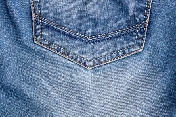 istock Blue jeans fabric texture. Distressed denim with back pocket background 1282695724