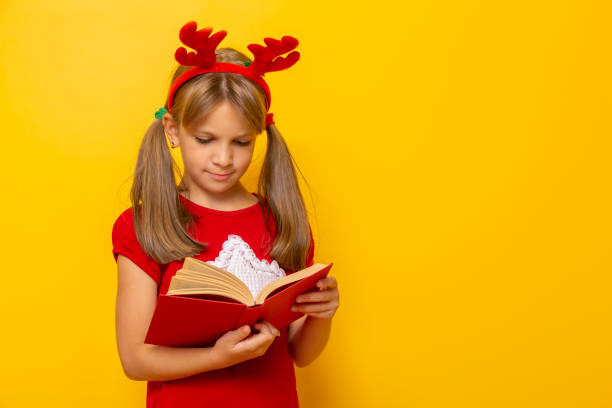 istock Little girl wearing antlers reading a book 1282696989