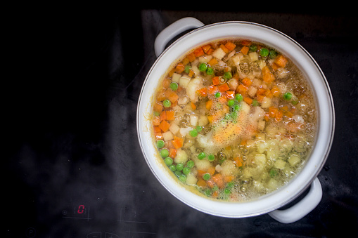 Boiling mixed vegetables for salad or minestrone soup on a stove