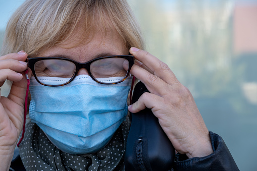 Woman with misted glasses due to protective mask
