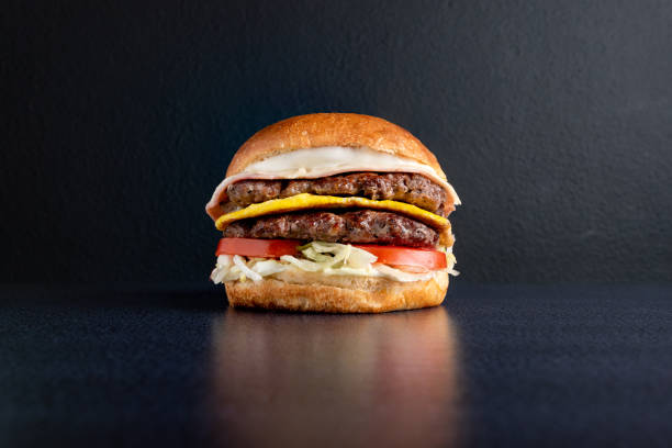 istock DOUBLE MEDALLON BURGER WITH CHEESE VEGETABLES AND DRESSINGS 1282700605