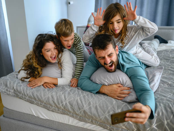 istock Family on bed taking selfie 1282701073