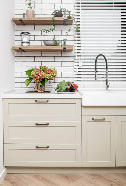 istock Kitchen interior near the wash basin with white cabinets in a minimal style. 1282701976