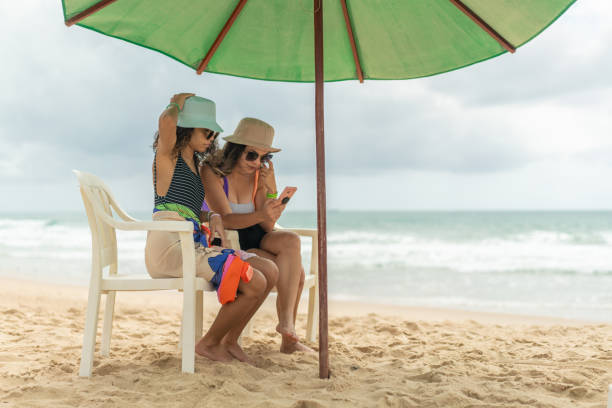 istock Women enjoying beach with smartphone 1282702275