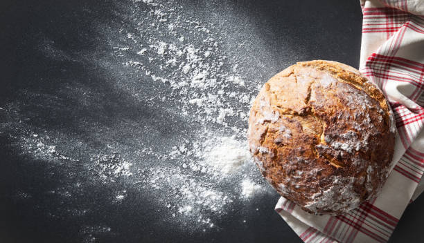 istock Freshly baked traditional loaf of bread on rustic table 1282703342