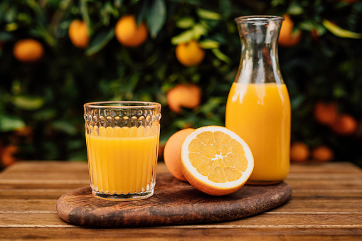 peeled juicy oranges and orange juice on the table, a table with orange citrus fruits close-up