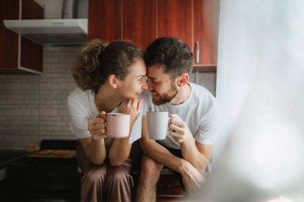 istock Young cheerful couple drinks tea or coffee in the kitchen 1282706059