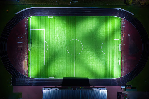 Bright illuminated soccer field at night. Direct above view