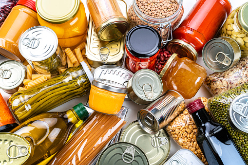 Non-perishable food background: canned goods, conserves, sauces and oils. Overhead view.