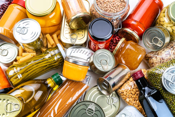 non-perishable food background: canned goods, conserves, sauces and oils. overhead view. - canned food imagens e fotografias de stock