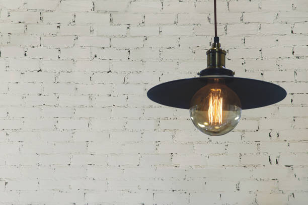 istock Industrial Style Light Pendant with Decorative Edison Filament Bulb on White Brick Wall Background 1282707372