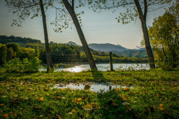 Sunset on the lake of the Sibillini mountains in the Marche region. Mountains reflected in the lake water. Autumn landscape with green, red and brown leaves.