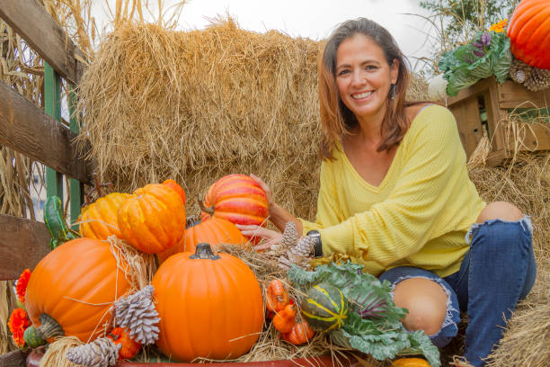 アメリカの感謝祭に農場の秋の日を楽しんでいる�ラテン美しい女性 - single flower flower autumn pumpkin ストックフォトと画像