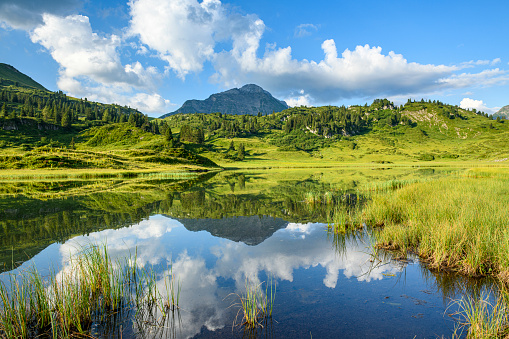 Calm water and reflections at the beautiful lake Kalbelesee in Vorarlberg, the most western part of Austria