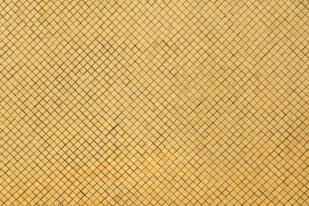 istock Golden or gold art grid square mosaic tiles wall pattern surface texture. Close-up of architecture interior shinny material for design decoration background. Thai style 1282711140
