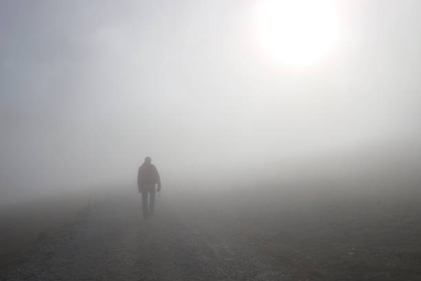 istock A man walks up a hill in dense fog. Austria. 1282712906