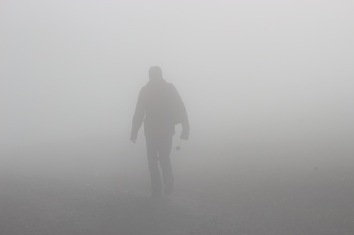 A man walks up a hill in dense fog. On a mountain footpath, height approx. 1300 m.  Hinterstoder, Upper Austria, Europe.