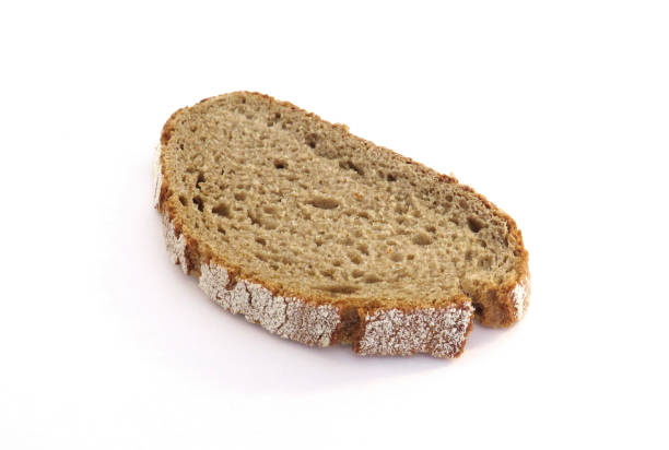 Aerial view of slice of artisan rye bread isolated on white background. Close-up of a piece of freshly baked artisan whole wheat bread. Rustic dark rye sourdough bread in horizontal position Aerial view of slice of artisan rye bread isolated on white background. Close-up of a piece of freshly baked artisan whole wheat bread. Rustic dark rye sourdough bread in horizontal position slice of bread stock pictures, royalty-free photos & images