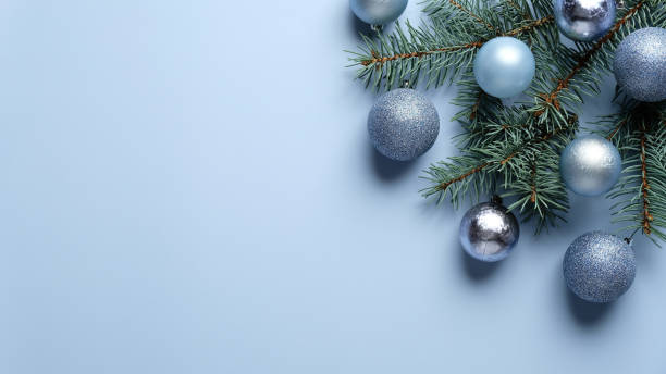 istock Elegant Christmas composition with blue and silver balls decoration and pine tree branch on pastel blue background. Flat lay, top view. 1282715622