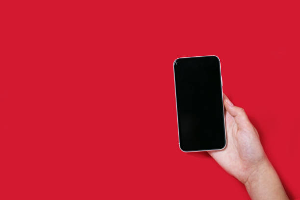 istock Hand holding a phone on the red background 1282718321