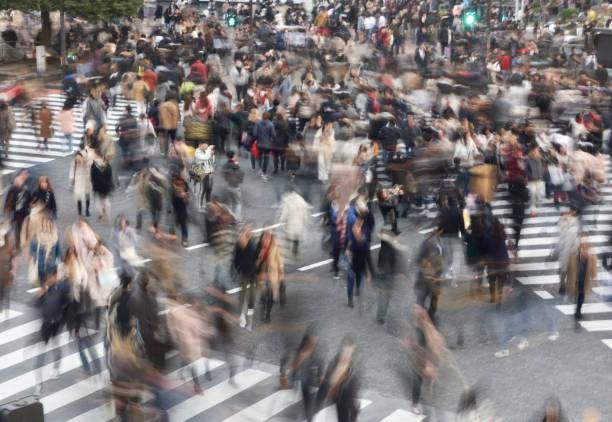 Blur motion of walking people in Shibuya crossing, Tokyo, Japan Blur motion of walking people in Shibuya crossing, Tokyo, Japan. Shibuya crossing is one of the most iconic place in Tokyo. Lots of people cross the road every day. tokyo crowds on the famous shibuya crossing japan stock pictures, royalty-free photos & images