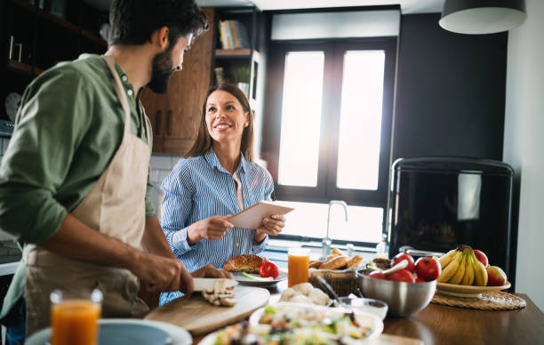 istock Happy couple cooking together in their kitchen 1282720537