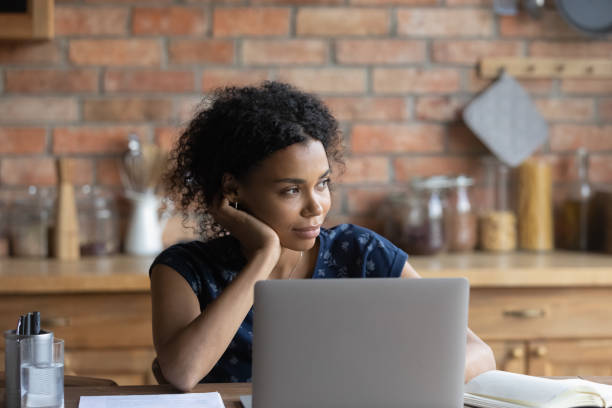 istock Young Africana American woman distracted from computer dreaming 1282721940