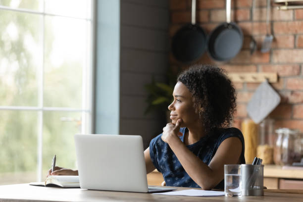 istock Dreamy biracial woman distracted from computer thinking 1282721952