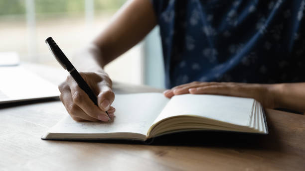 istock Crop of woman writing in notebook making plans 1282721978