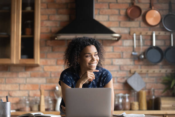 istock Smiling African American woman dram distracted from computer work 1282721985