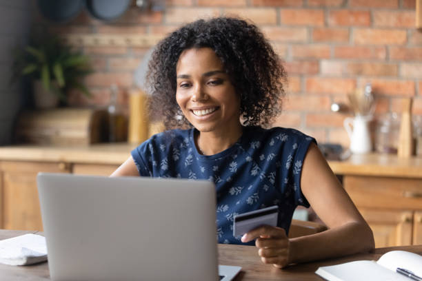 istock Smiling biracial female make payment on laptop online 1282721995