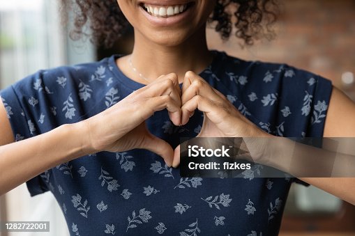 istock Smiling biracial woman show heart hand gesture 1282722001