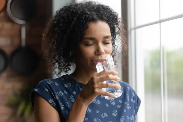 Photo of African American woman feel thirsty drinking water