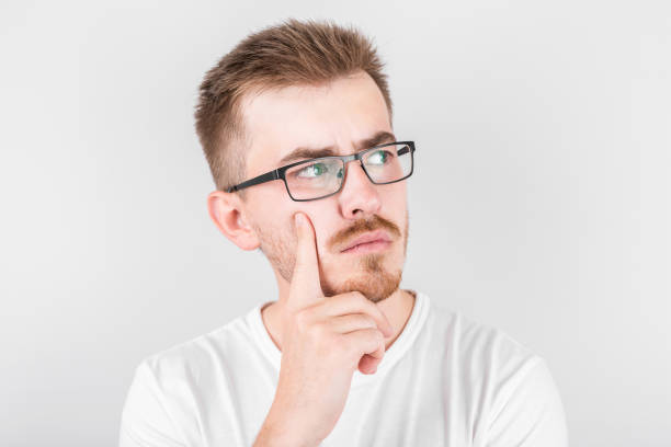 Photo of thoughtful man isolated over white background wall. Looking aside.