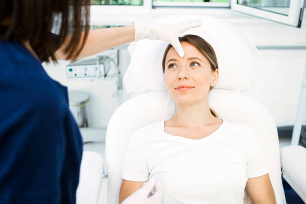 cosmetologist preparing patient for facial treatments - exfoliating scrub imagens e fotografias de stock