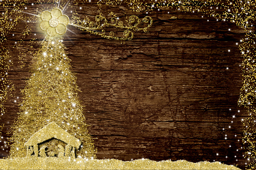 Christmas Nativity Scene and tree, religious greetings cards. Abstract freehand drawing of Nativity Scene and  Christmas tree with gold glitter on old wooden table with copy space.