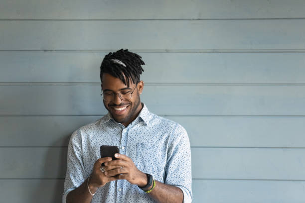istock Smiling biracial man browsing modern smartphone gadget 1282728237