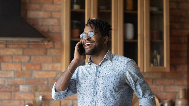 istock Smiling young biracial man laugh talking on cellphone 1282728275