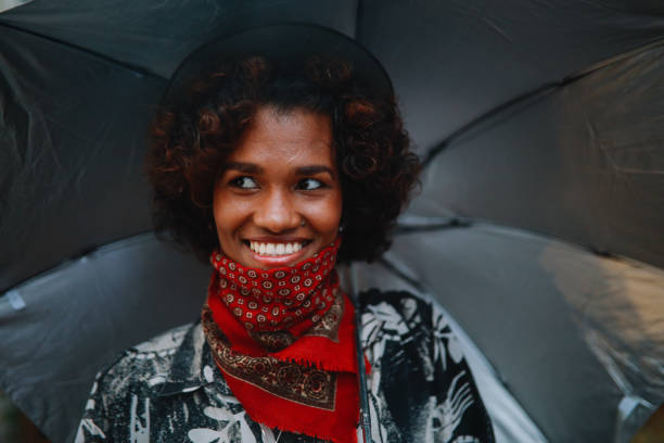 ritratto di una giovane donna nera che indossa una ghetta al collo - candid women african descent umbrella foto e immagini stock