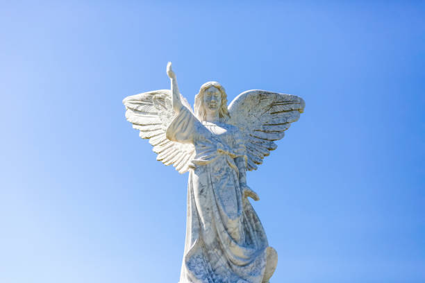 istock Angel, old statue of angle, front view, light blue sky background with copy space 1282730126