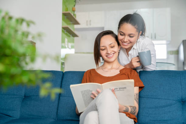 istock Lesbian couple relaxing at home and reading a book 1282730261