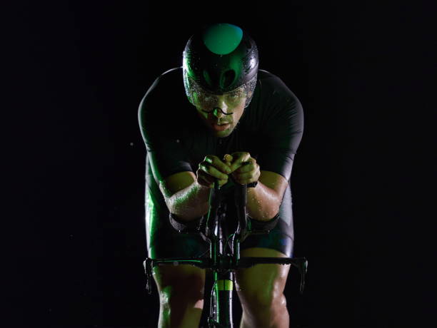 istock triathlon athlete riding bike fast at night 1282730993
